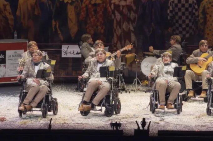 Un grupo de carnaval español se viste como Stephen Hawking y se desplaza en sillas de ruedas en una actuación extraña para crear conciencia sobre la ELA